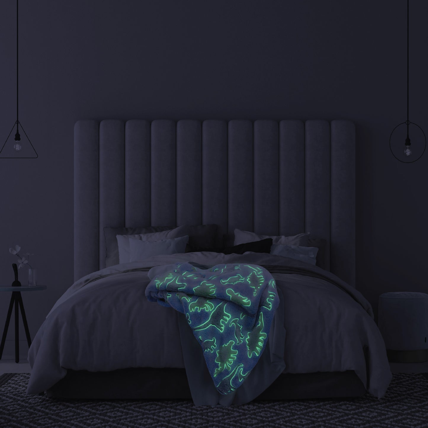 The Glow in the Dark Throw Blanket in Blue and Green Dinosaurs spread across a children's bed, glowing in the dark.