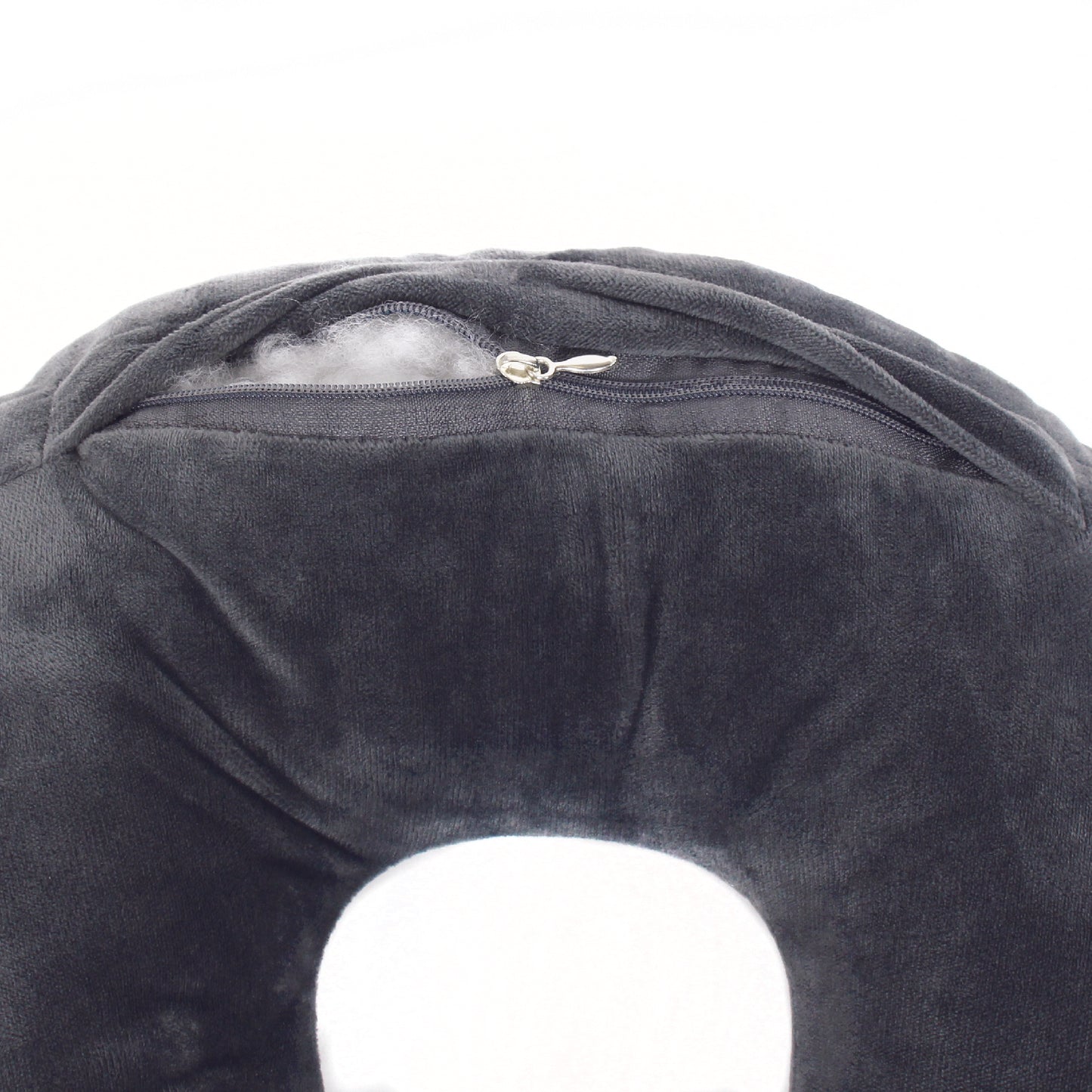 Close up view of the zipper opening on the Plush Travel Neck Pillow in Gray, which is exposing the plush interior inside the pillow's cover.