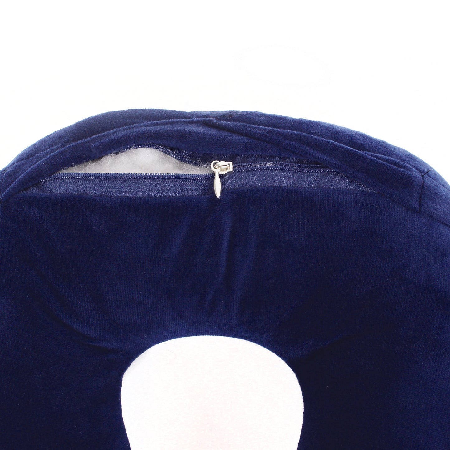 Close up view of the zipper opening on the Plush Travel Neck Pillow in Navy, which is exposing the plush interior inside the pillow's cover.
