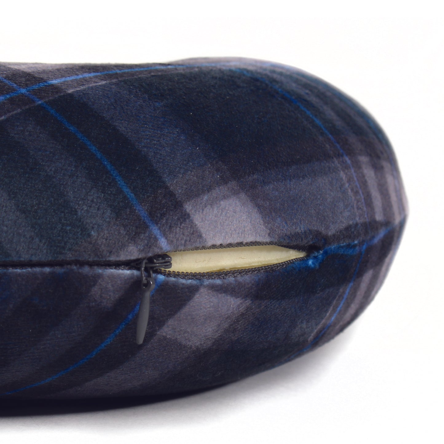 Close up view of the zipper opening on the Memory Foam Travel Neck Pillow in Navy Plaid, which is exposing the plush interior inside the pillow's cover.