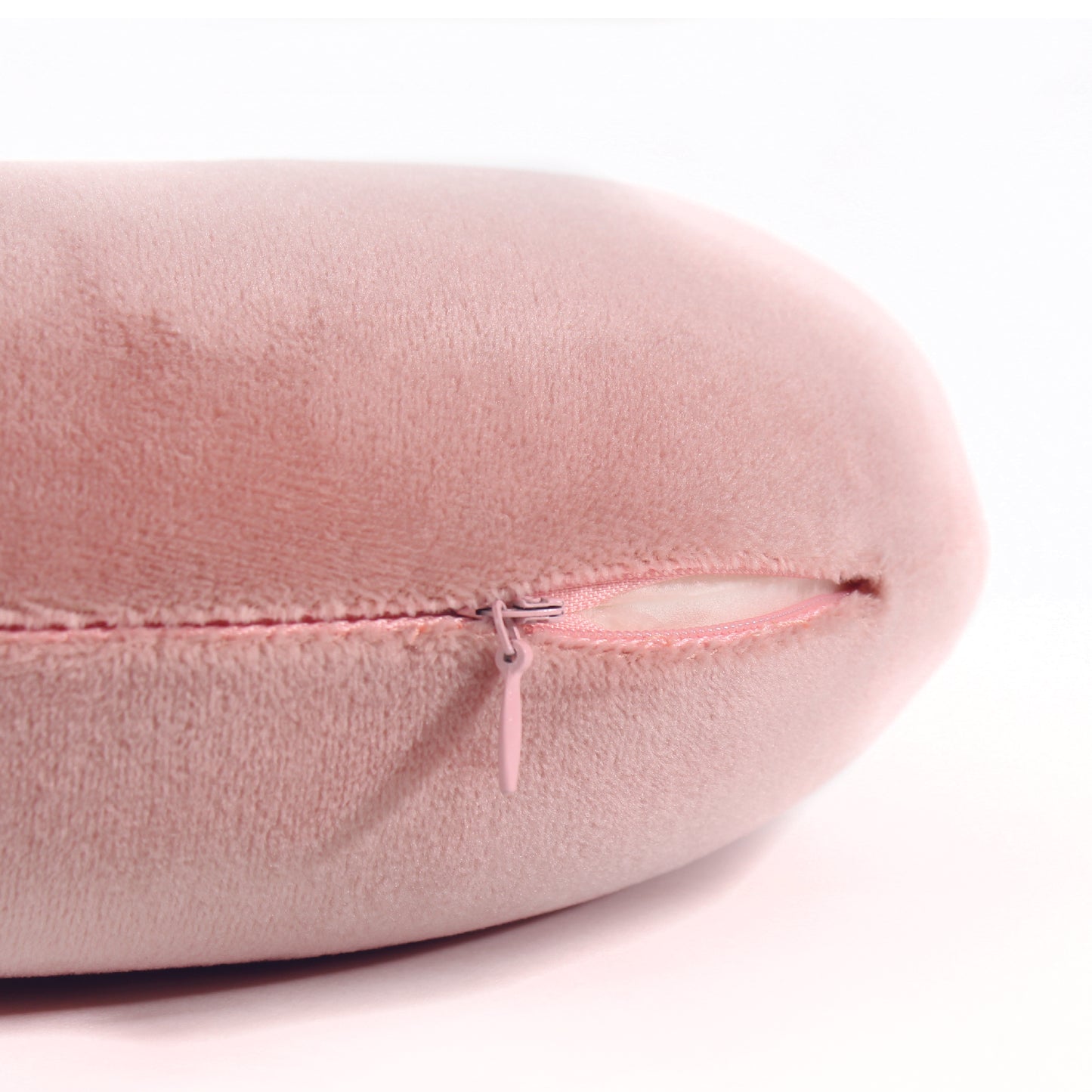 Close up view of the zipper opening on the Memory Foam Travel Neck Pillow in Pink, which is exposing the plush interior inside the pillow's cover.