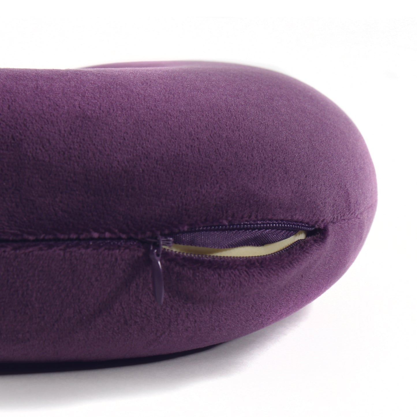 Close up view of the zipper opening on the Memory Foam Travel Neck Pillow in Purple, which is exposing the plush interior inside the pillow's cover.