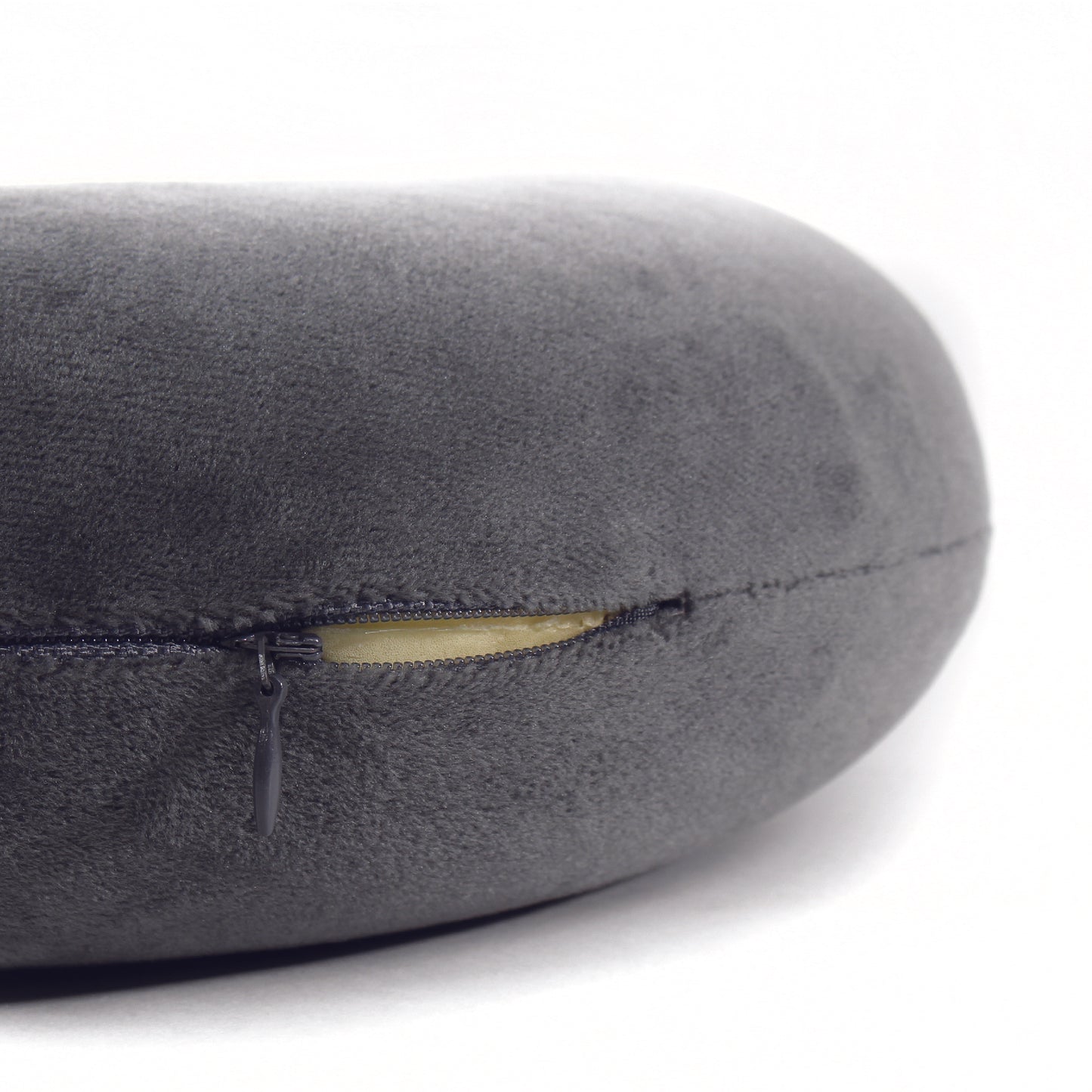Close up view of the zipper opening on the Memory Foam Travel Neck Pillow in Gray, which is exposing the plush interior inside the pillow's cover.