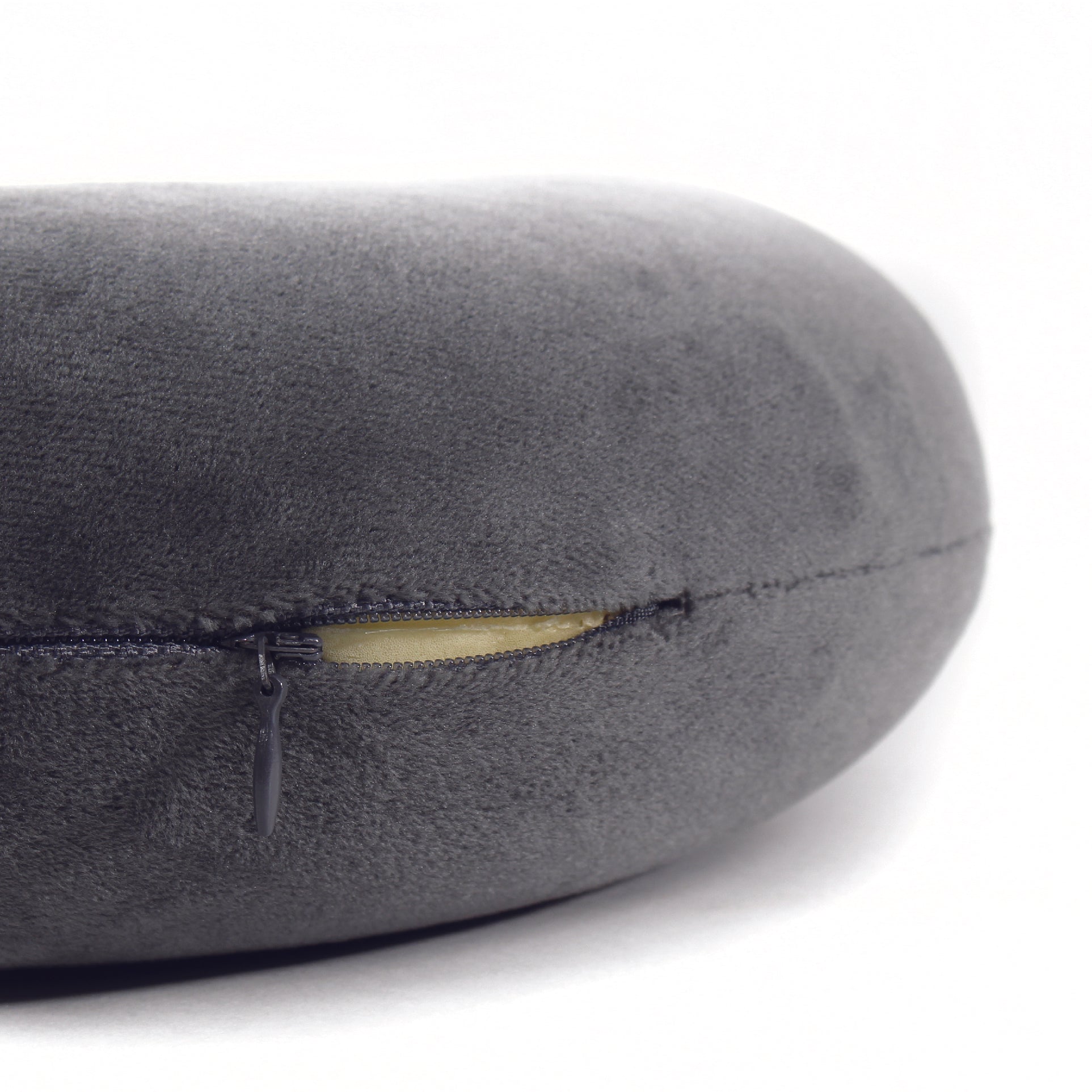 Close up view of the zipper opening on the Memory Foam Travel Neck Pillow in Gray, which is exposing the plush interior inside the pillow's cover.
