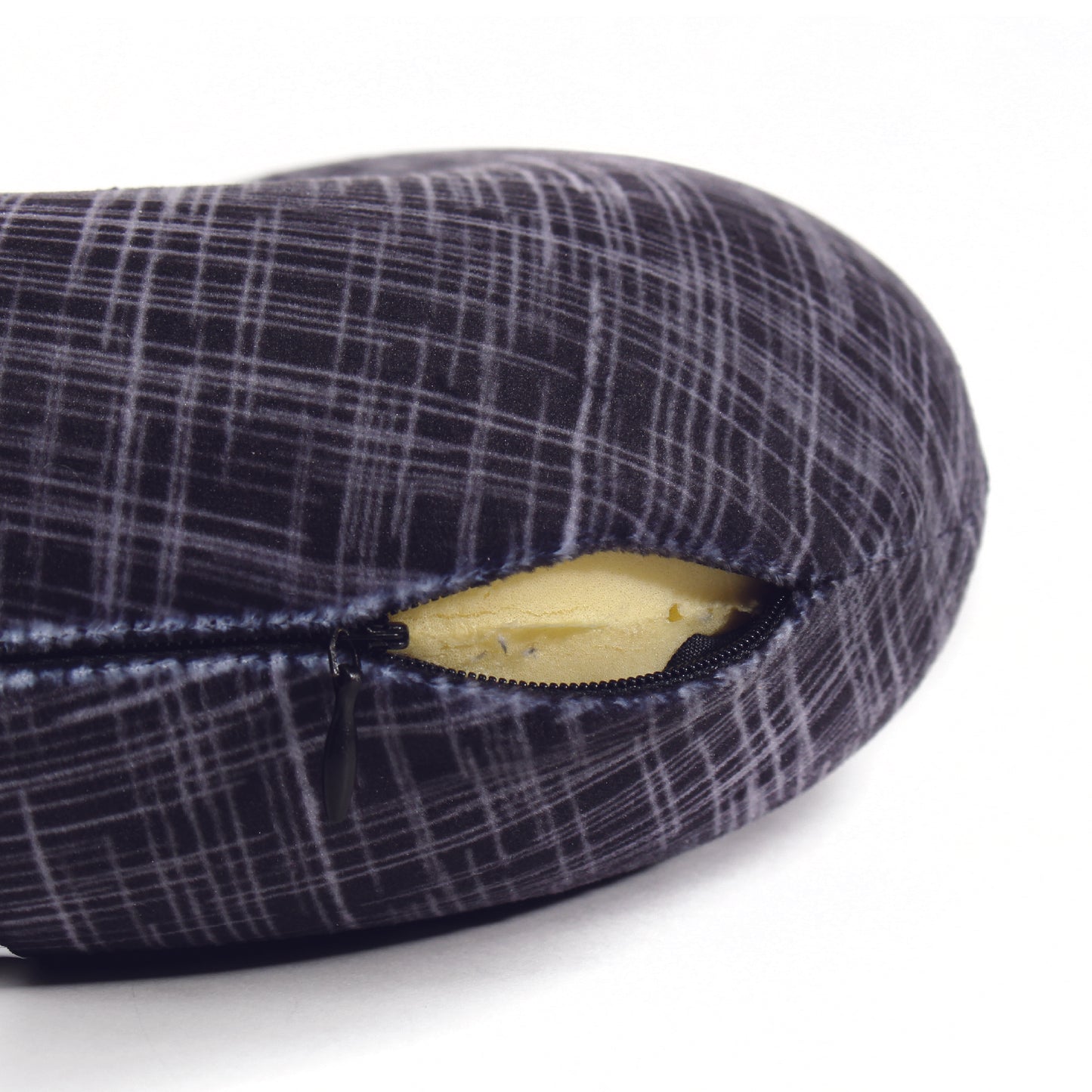 Close up view of the zipper opening on the Memory Foam Travel Neck Pillow in Black Hatch, which is exposing the plush interior inside the pillow's cover.