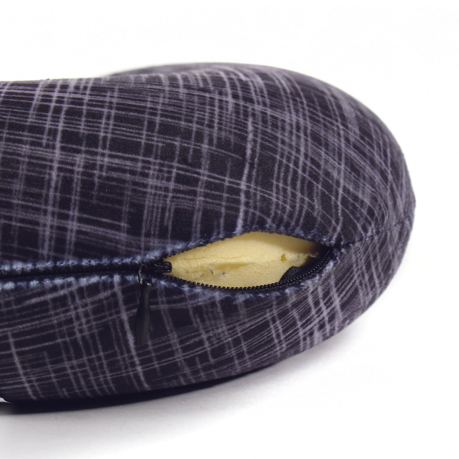 Close up view of the zipper opening on the Memory Foam Travel Neck Pillow in Black Hatch, which is exposing the plush interior inside the pillow's cover.