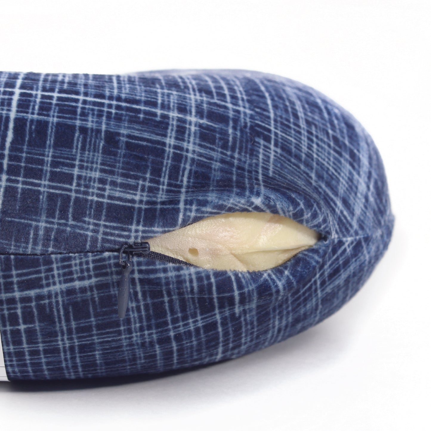 Close up view of the zipper opening on the Memory Foam Travel Neck Pillow in Navy Hatch, which is exposing the plush interior inside the pillow's cover.