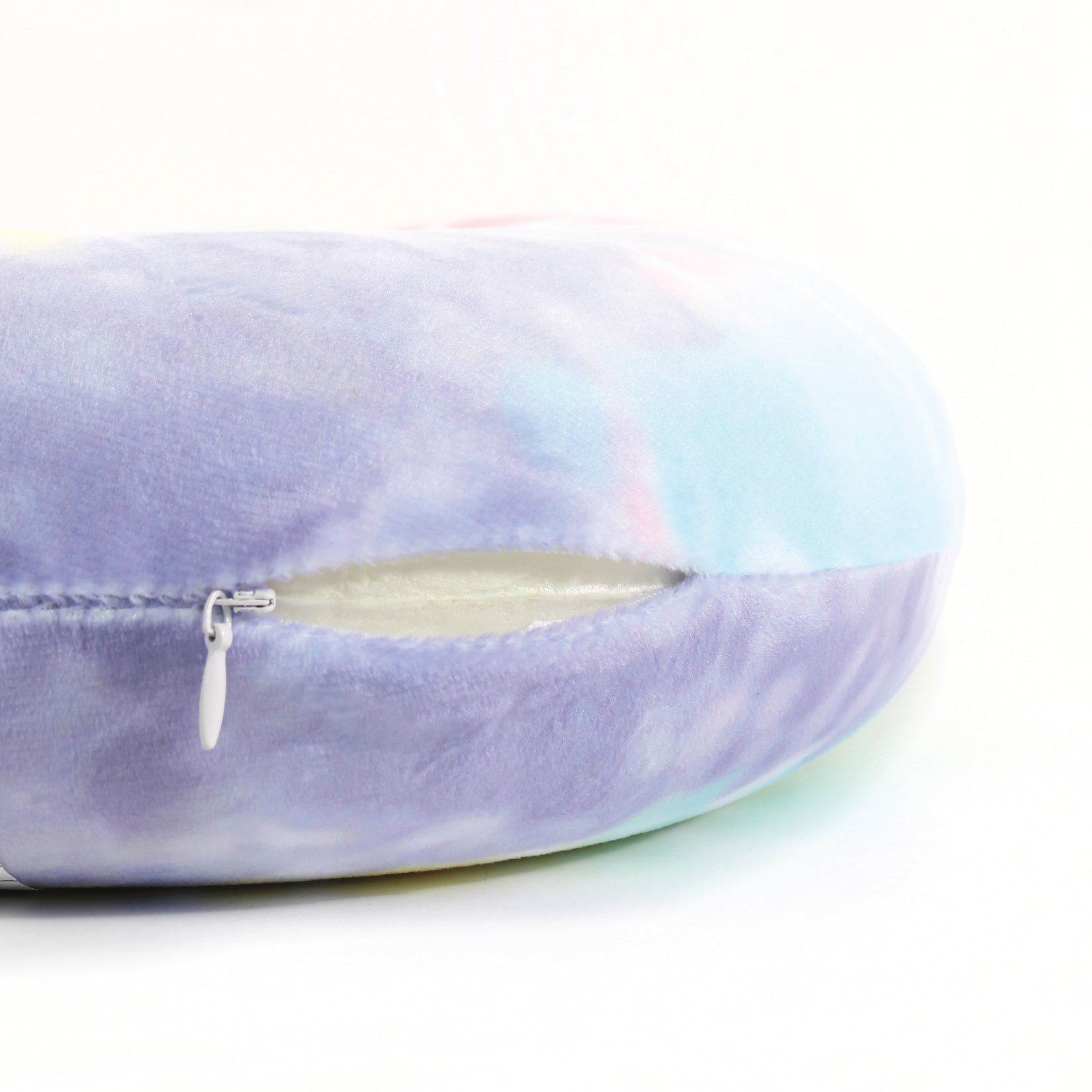 Close up view of the zipper opening on the Memory Foam Travel Neck Pillow in Multicolor Tie Dye, which is exposing the plush interior inside the pillow's cover.