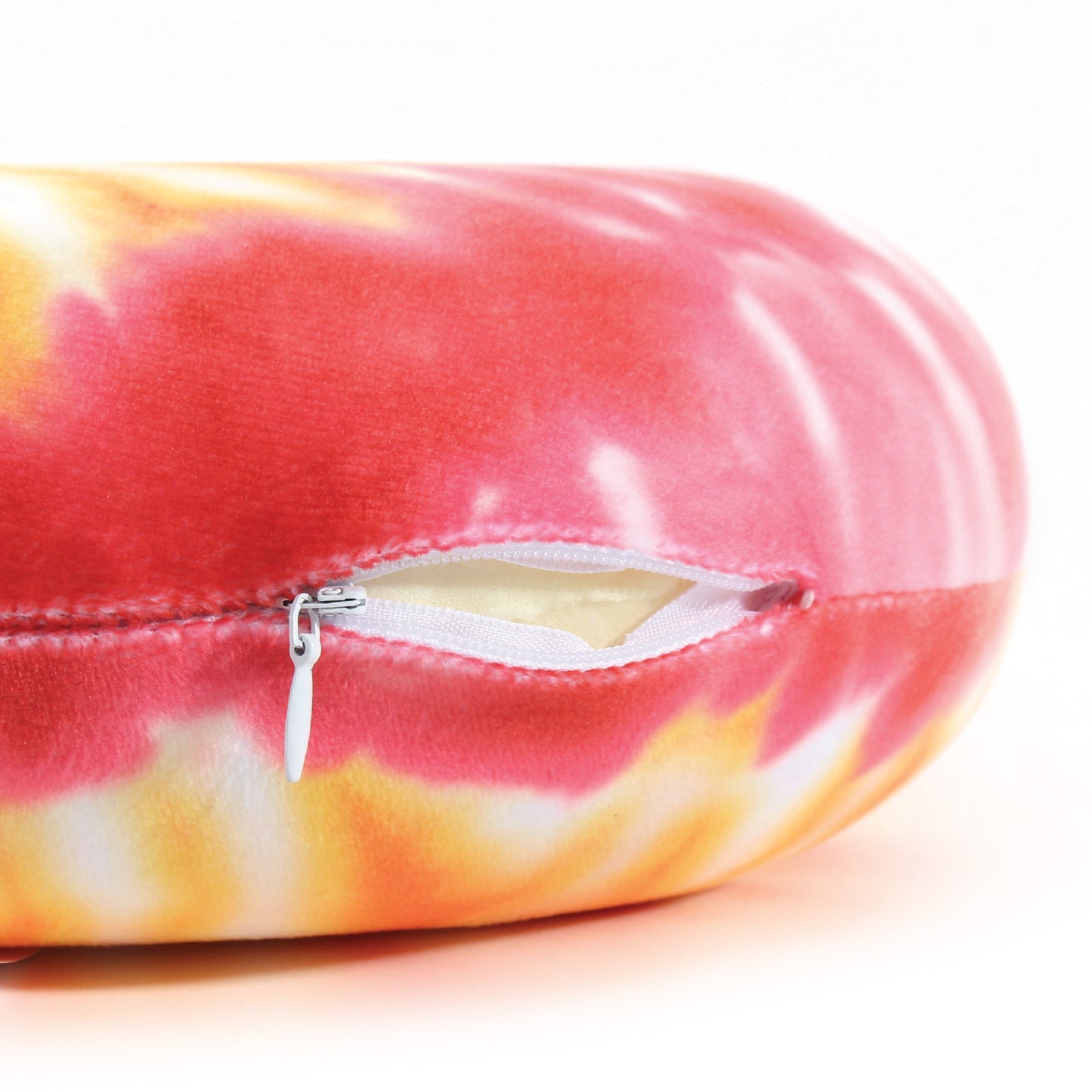 Close up view of the zipper opening on the Memory Foam Travel Neck Pillow in Red and Yellow Tie Dye, which is exposing the plush interior inside the pillow's cover.
