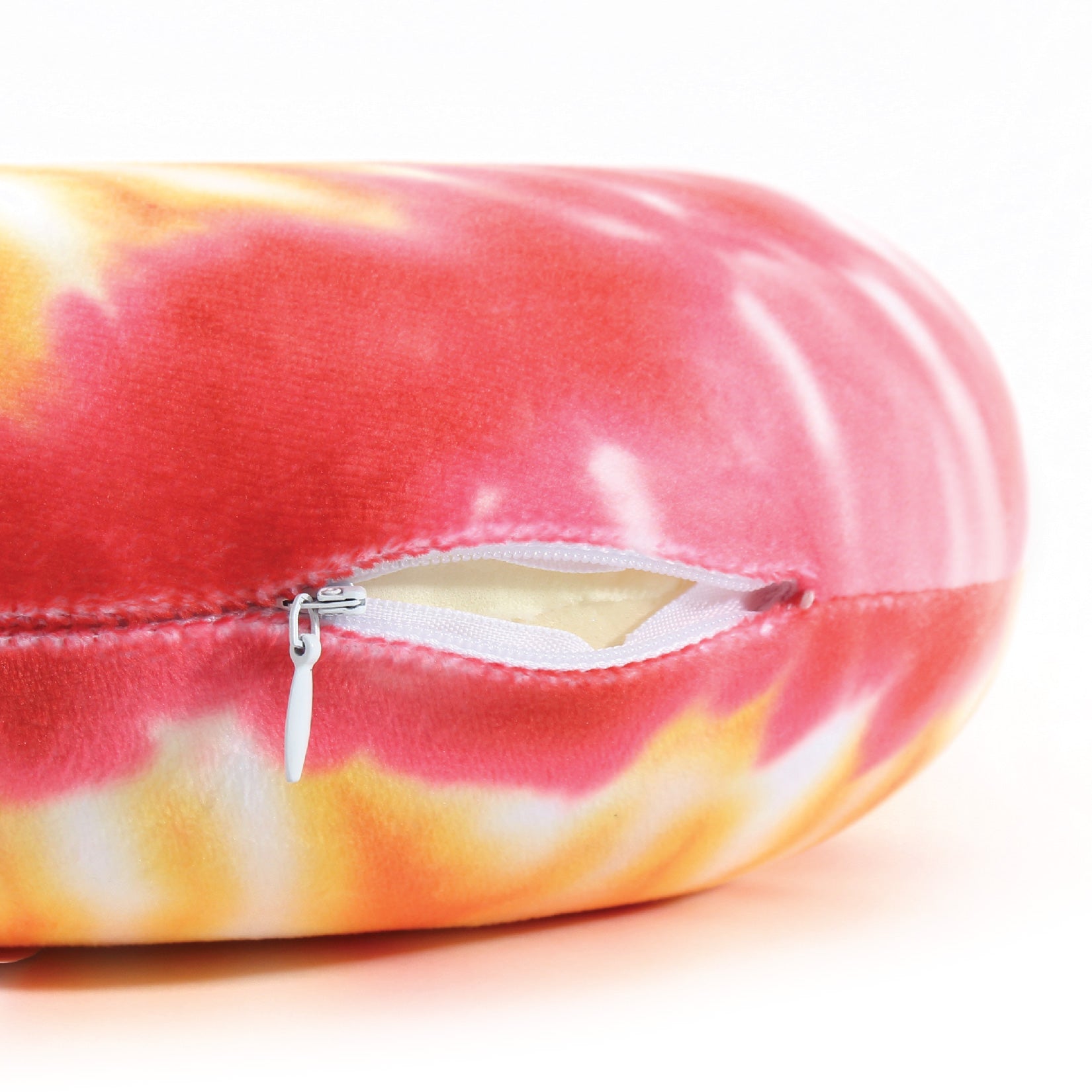 Close up view of the zipper opening on the Memory Foam Travel Neck Pillow in Red and Yellow Tie Dye, which is exposing the plush interior inside the pillow's cover.