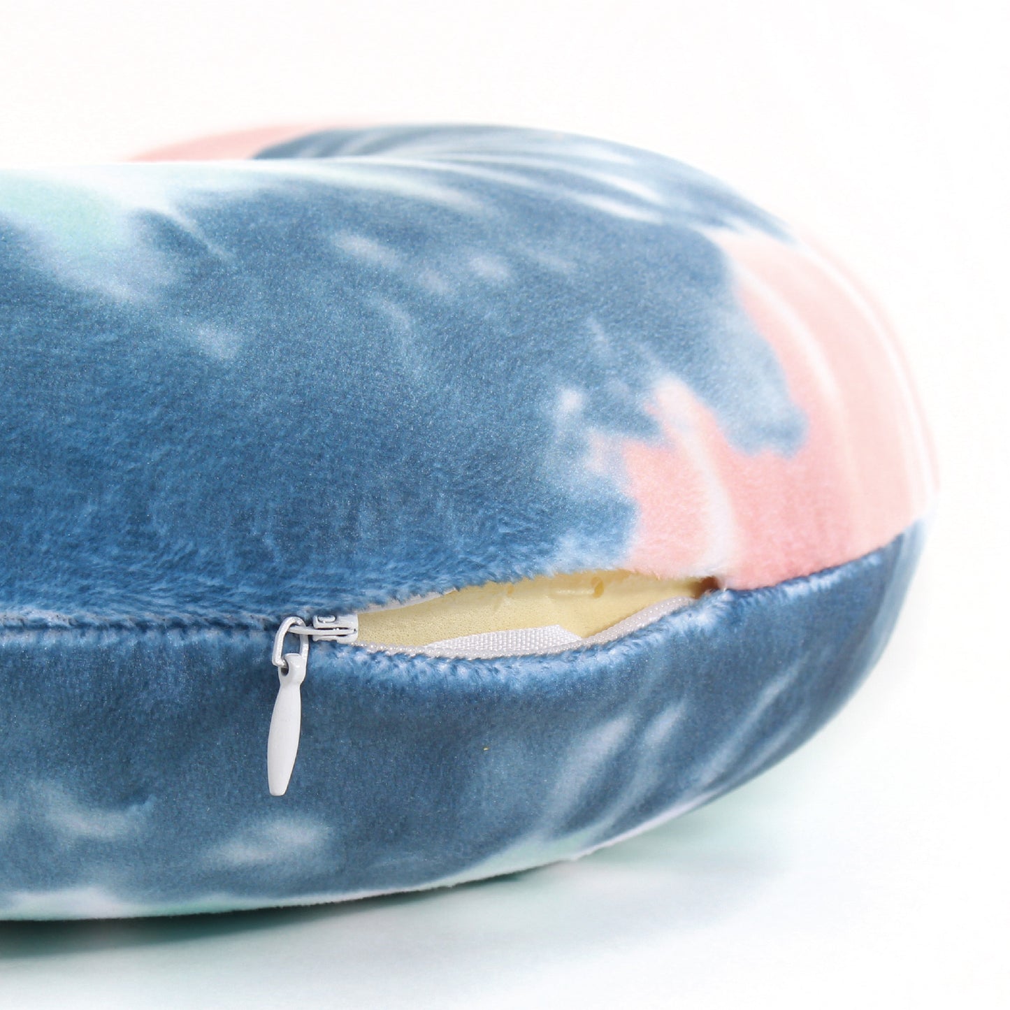 Close up view of the zipper opening on the Memory Foam Travel Neck Pillow in Peach and Gray Tie Dye, which is exposing the plush interior inside the pillow's cover.