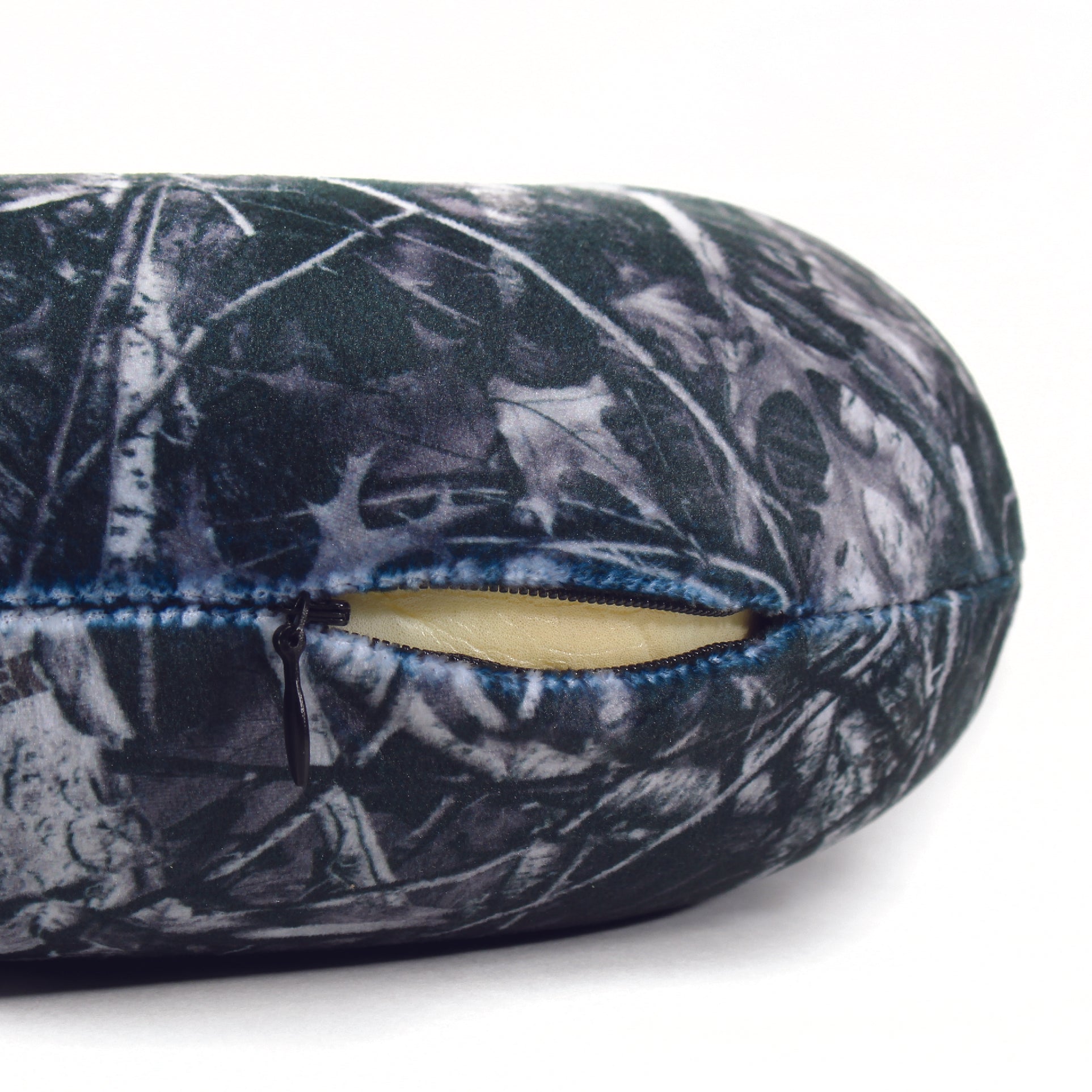 Close up view of the zipper opening on the Memory Foam Travel Neck Pillow in Hunter's Stock Moonshot® Camo, which is exposing the plush interior inside the pillow's cover.