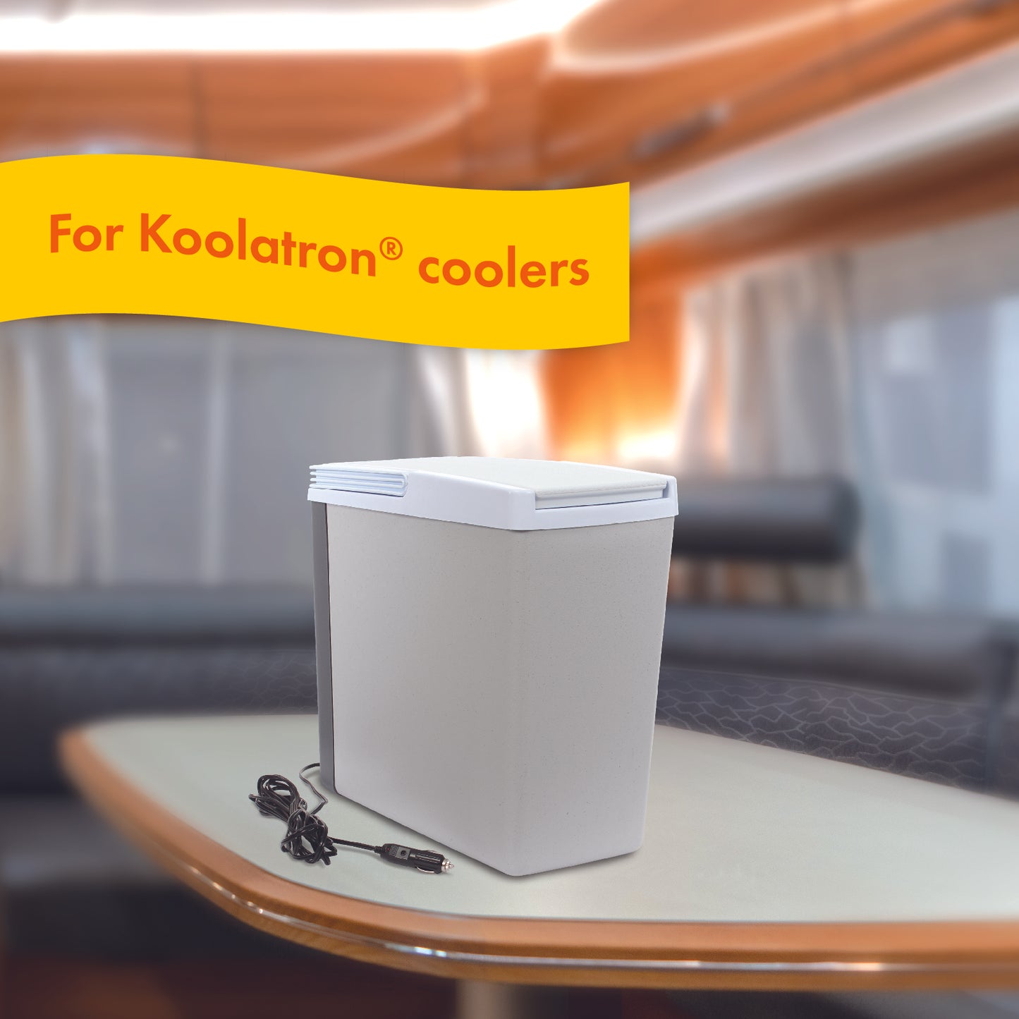 The Replacement Power Cord for Koolatron Coolers is plugged into a cooler as it sits atop a table within a travel RV van.