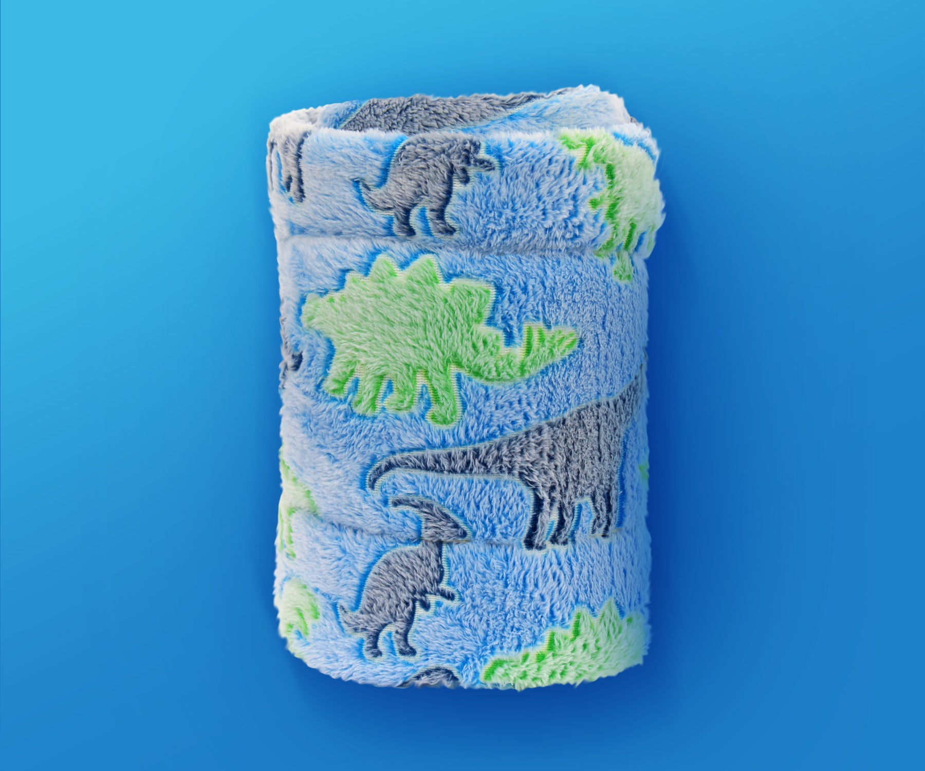 Glow in the Dark Throw Blanket with dinosaur print atop a bright blue background