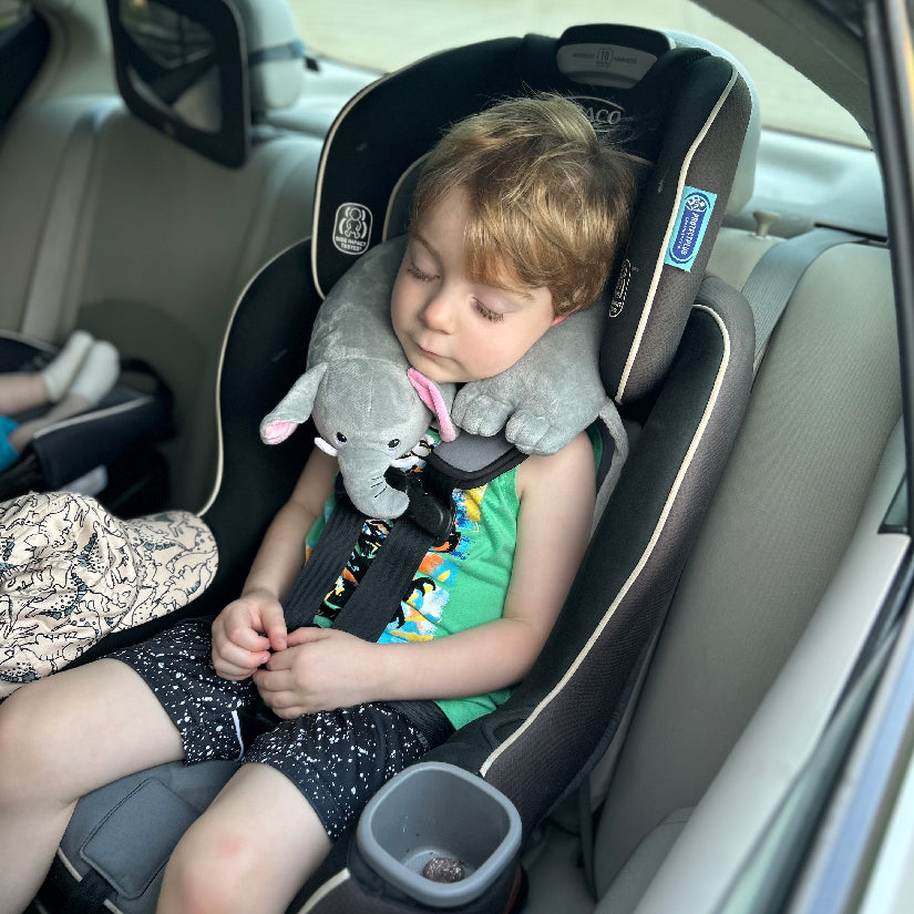 Youngster in his carseat wearing a Kids' Junior Elephant Travel Pillow